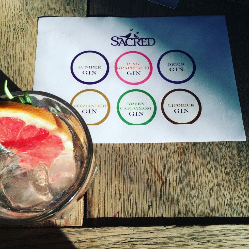 Sacred G&T next to the tasting mat of 6 different Sacred gins