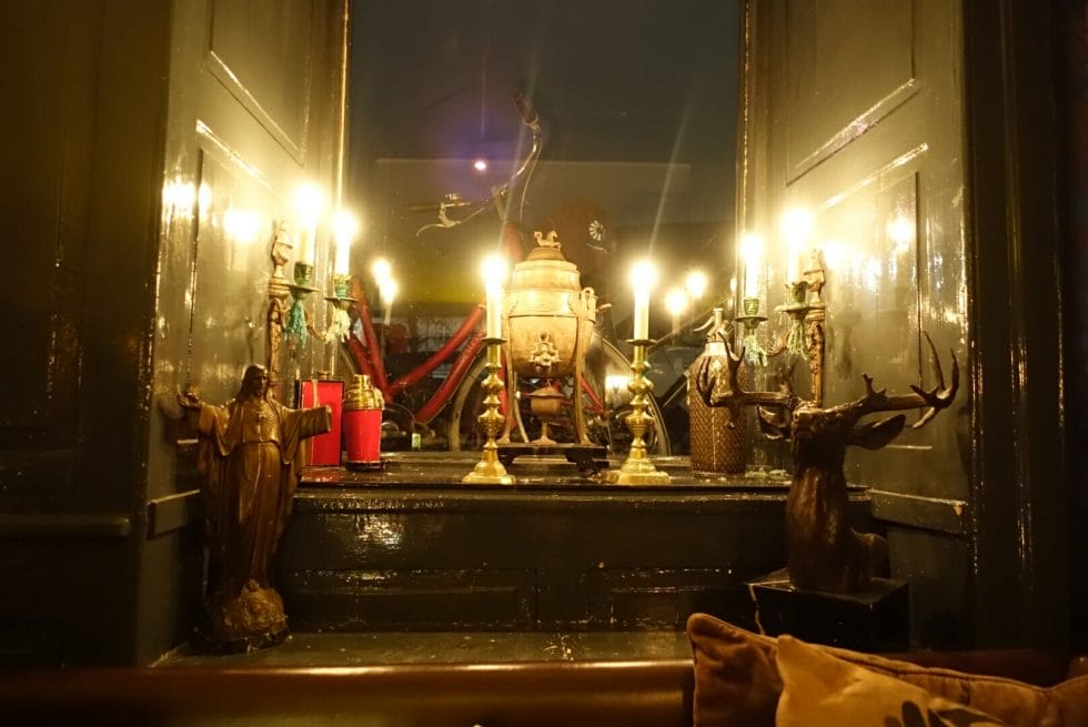 An eclectir decor of candles and random statues in the window