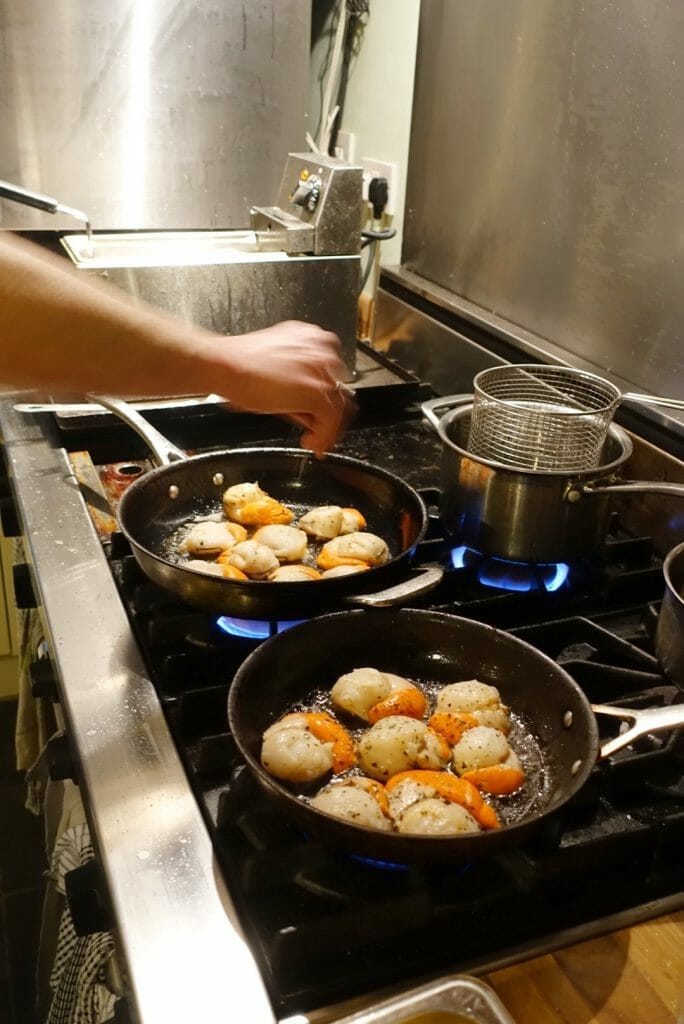 Scallops cooking in pans in the kitchen