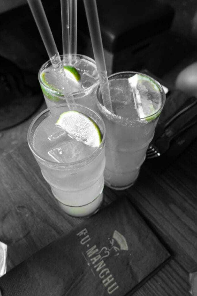 Black and white shot of cocktails with the lime still green