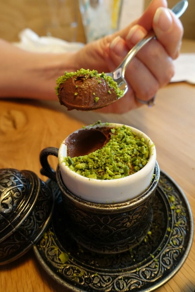 Spoon of pistachio topped chocolate mousse