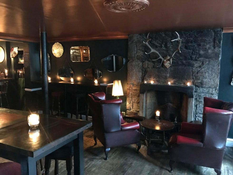 The cosy interior of The Last Word bar with armchairs and stag antlers
