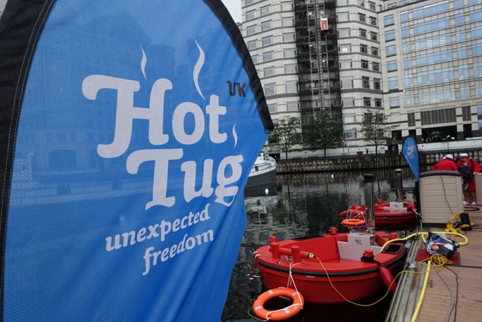 The HotTug sign and HotTug boat in the water behind it