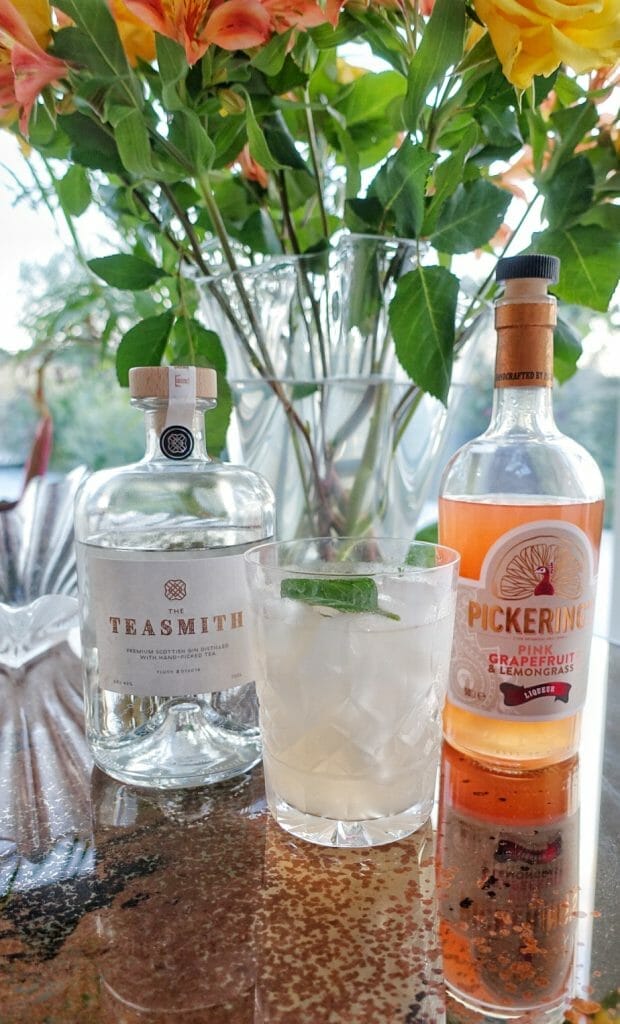 The Teasmith gin, Scottish Collins cocktail and Pickering's gin liqueur in front of a vase of flowers
