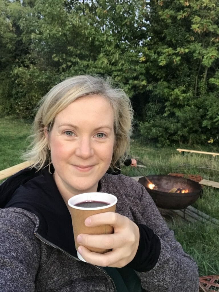 Katie enjoying a cup of mulled wine by the campfire