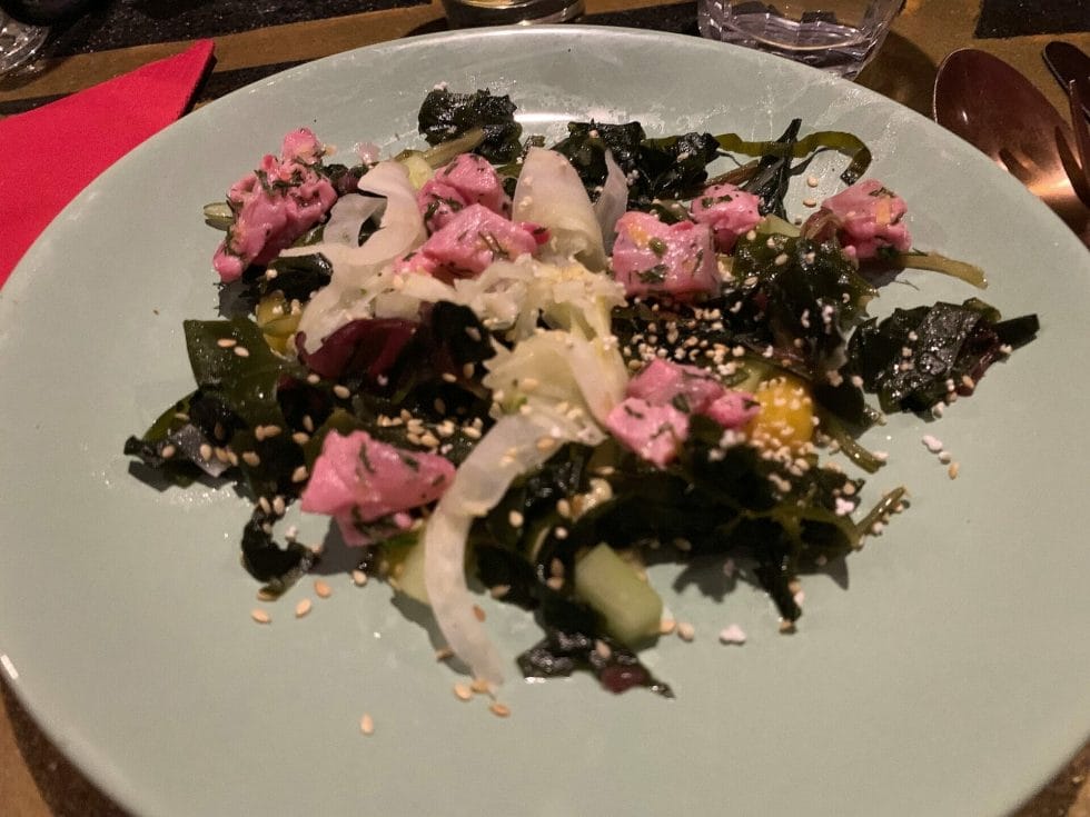 Ceviche on seaweed salad with yuzu dressing and sesame seeds