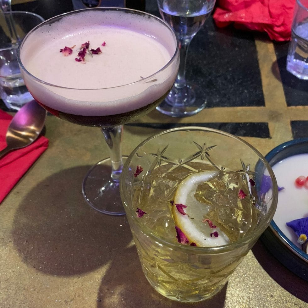 Espresso martini and white negroni, both decorated with rose petals