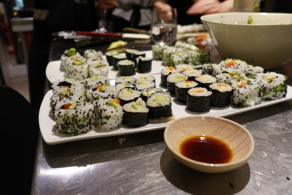 Plates full of sushi and a bowl of soy sauce