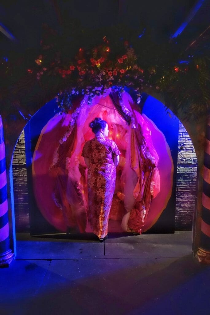 Becky posing at the entrance to Mount Olympus - decorated as pink vaginal lips