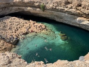 People swimming in swimming costumes in Bimmah sinkhole