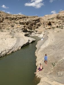 Coppia sulle rocce al fianco di Wadi Bani Khalid 