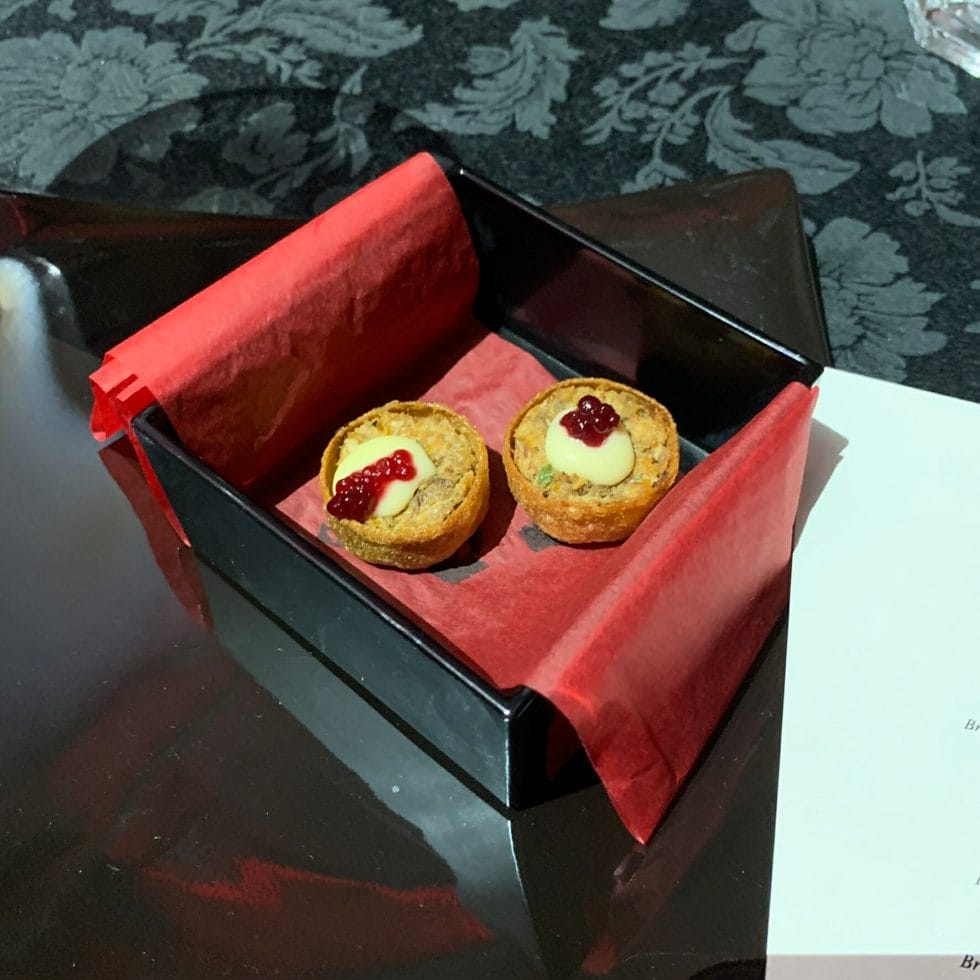 Two game tartlets in a black lacquer box with red tissue paper