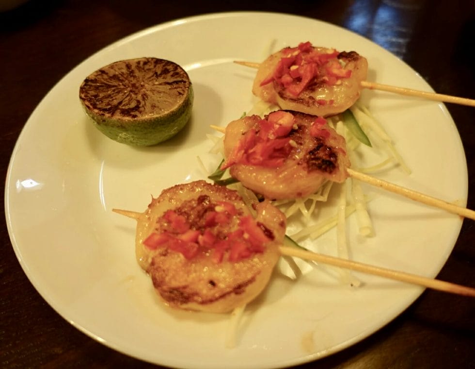 Prawns served like lollipops on sticks with fresh chili on top