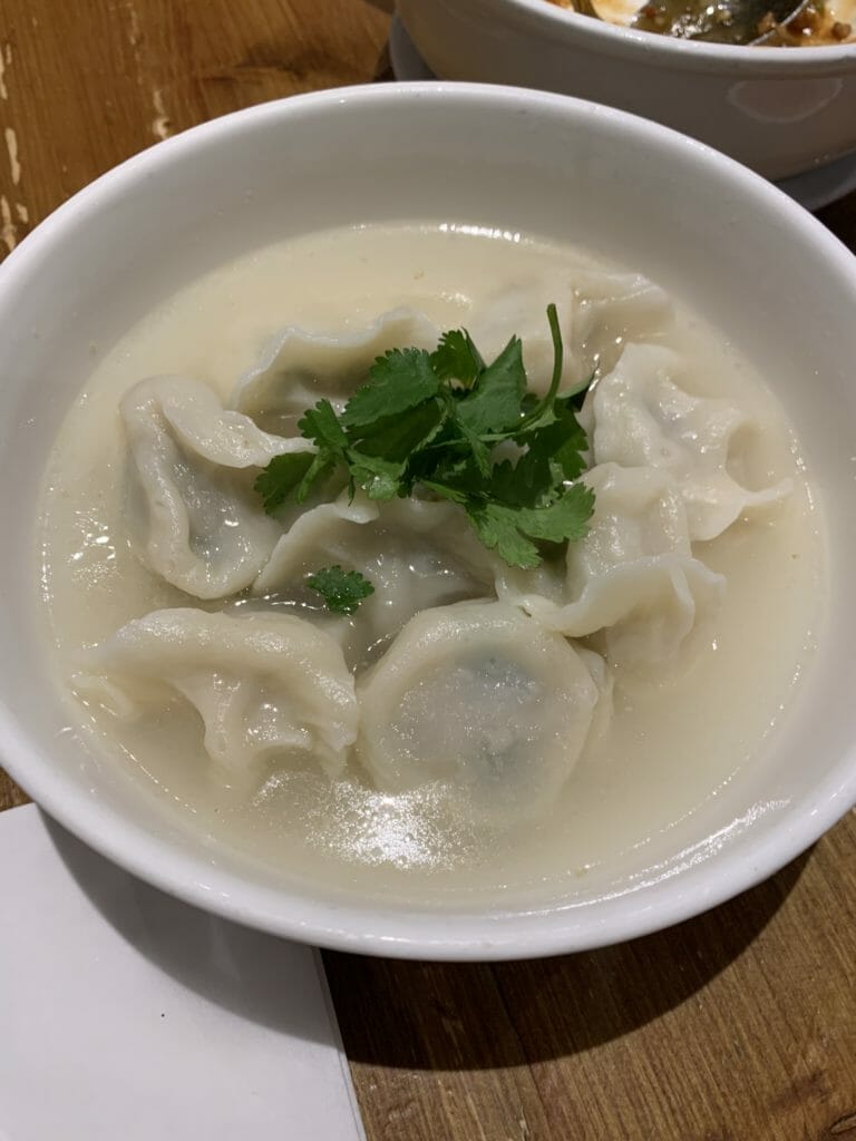 Soup with pork dumplings and coriander leaf on top