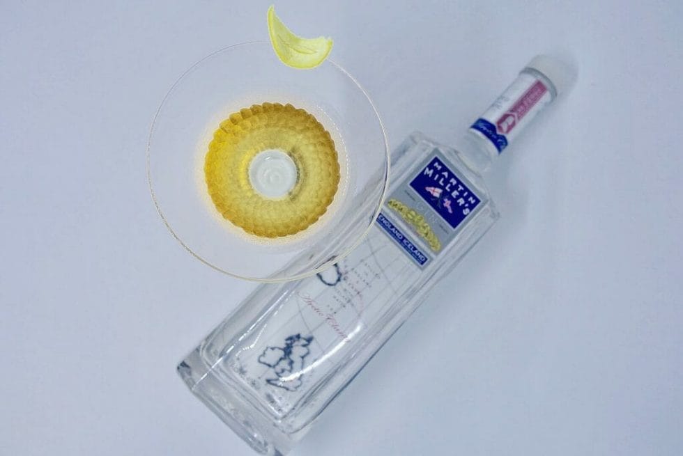Martin Millers gin bottle and martini glass with lemon peel garnish