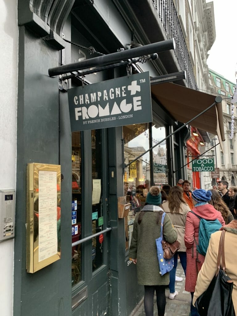 The sign and frontage of Champagne + Fromage