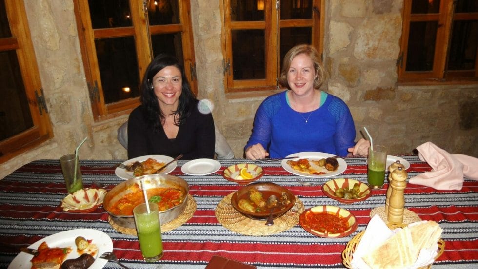Katie and friend eating a traditional dinner wearing jumpers