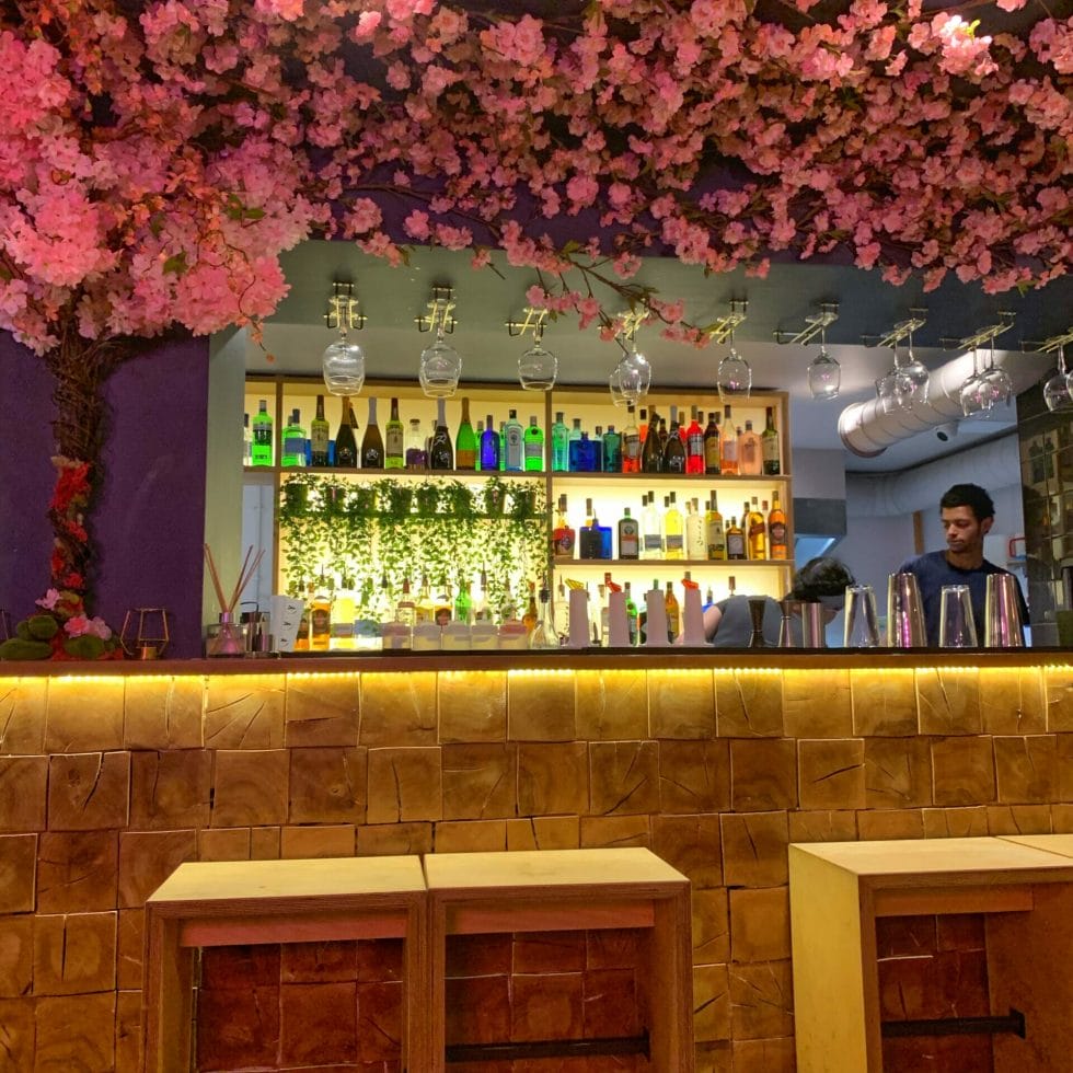 The bar area with a cascade of fake pink flowers growing over it