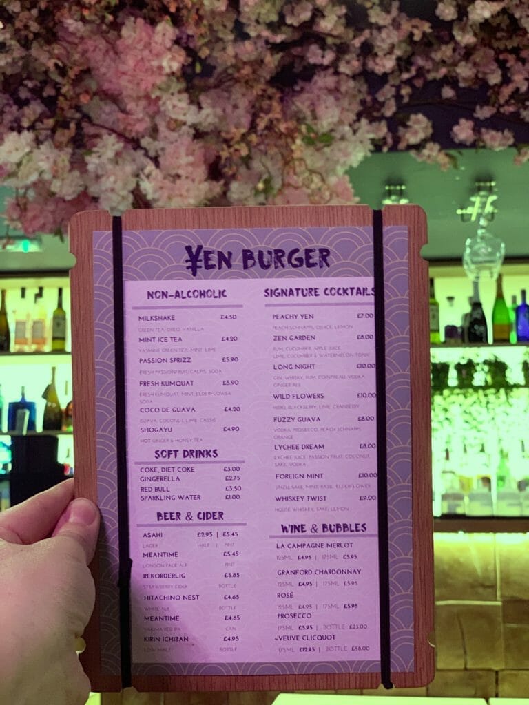 The Yen burger drinks menu being held up with the floral bar in the background