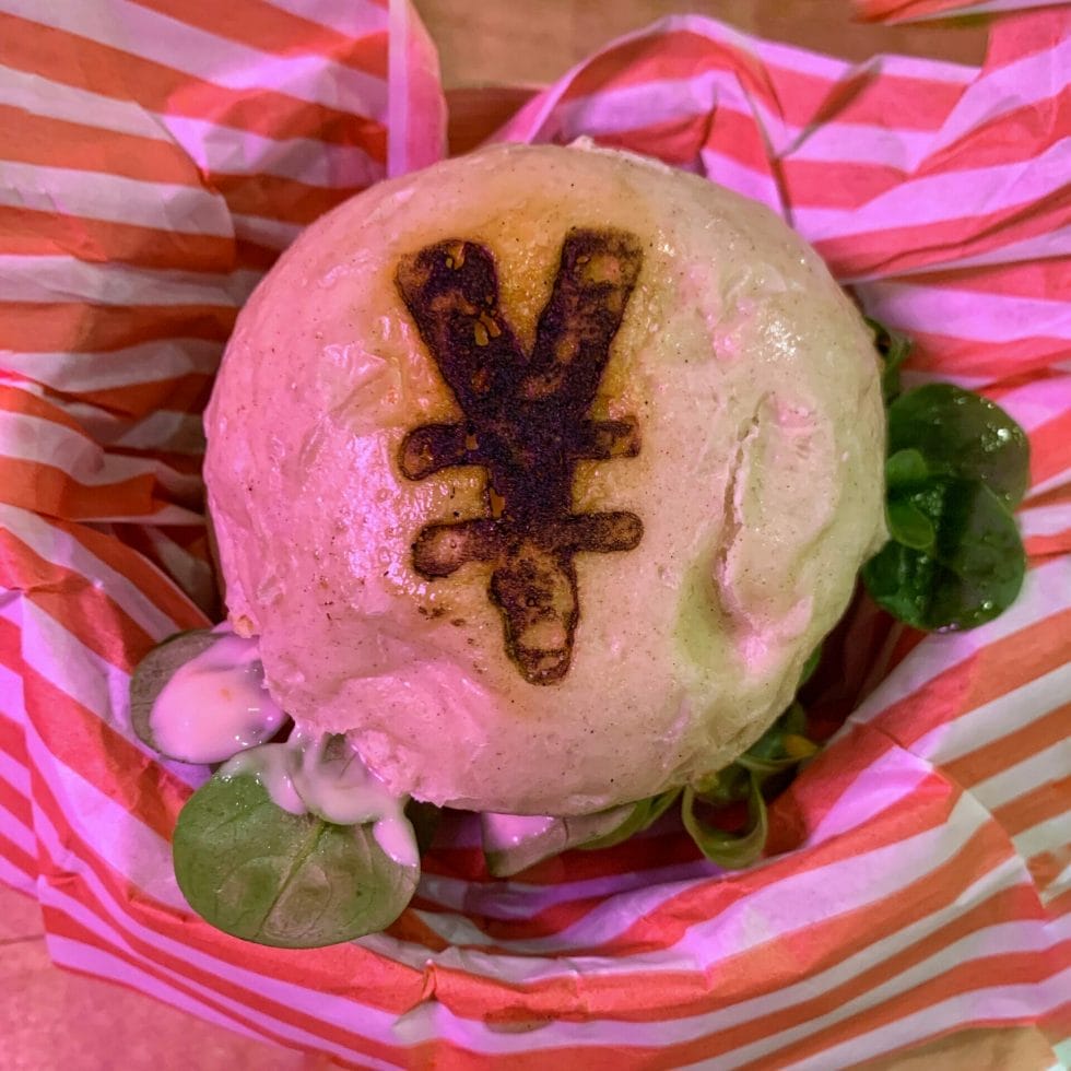Overhead view of the burger showing the Japanese Yen currency symbol stamped on the bun