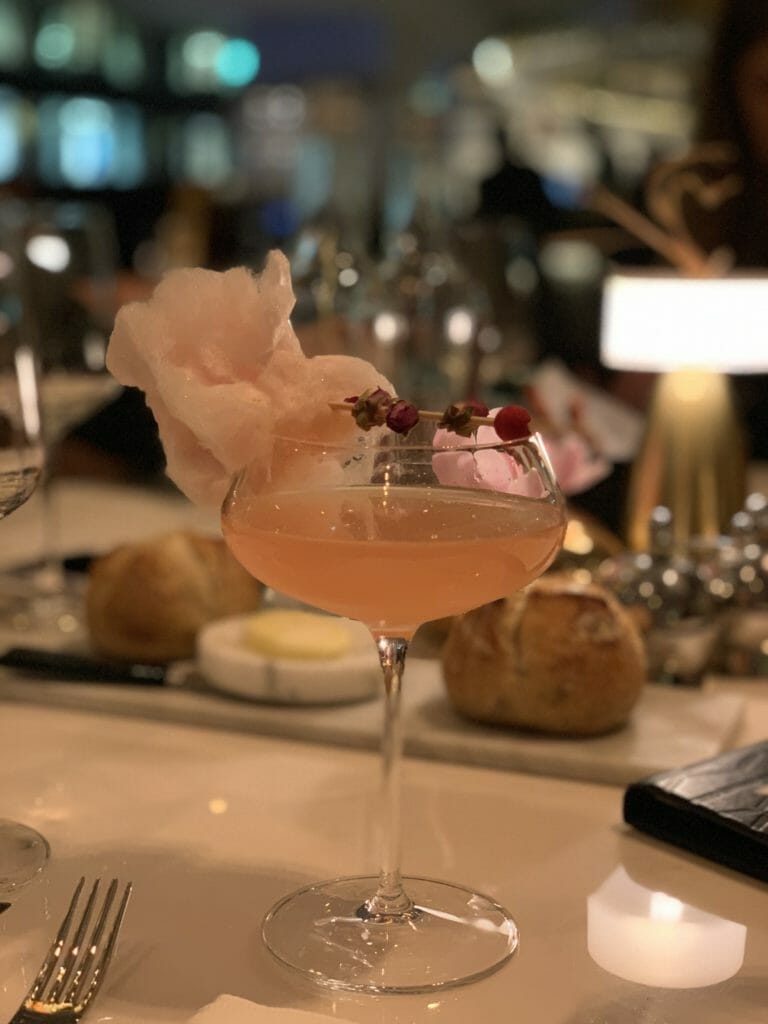 The Seifert cocktail in a coupe glass with a garnish of candy floss