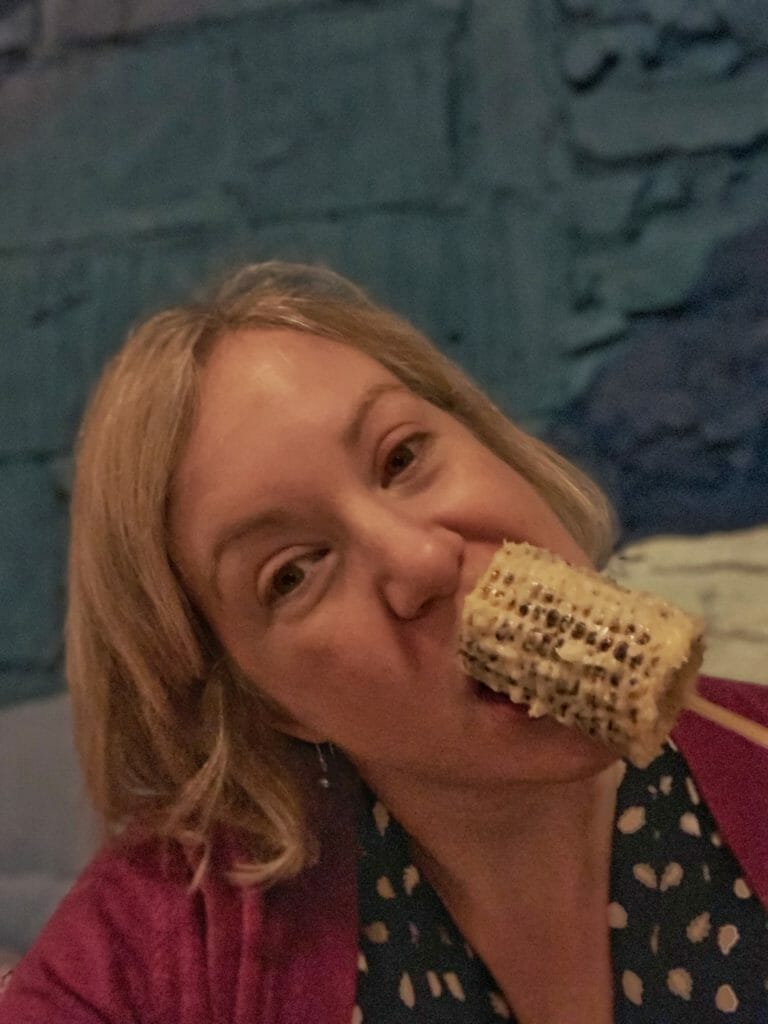 Katie eating the corn on the cob elote