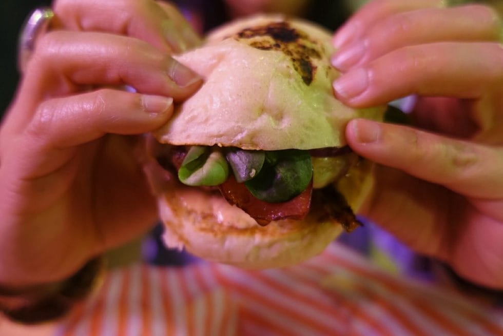 Close up of the Yen Supreme burger held up