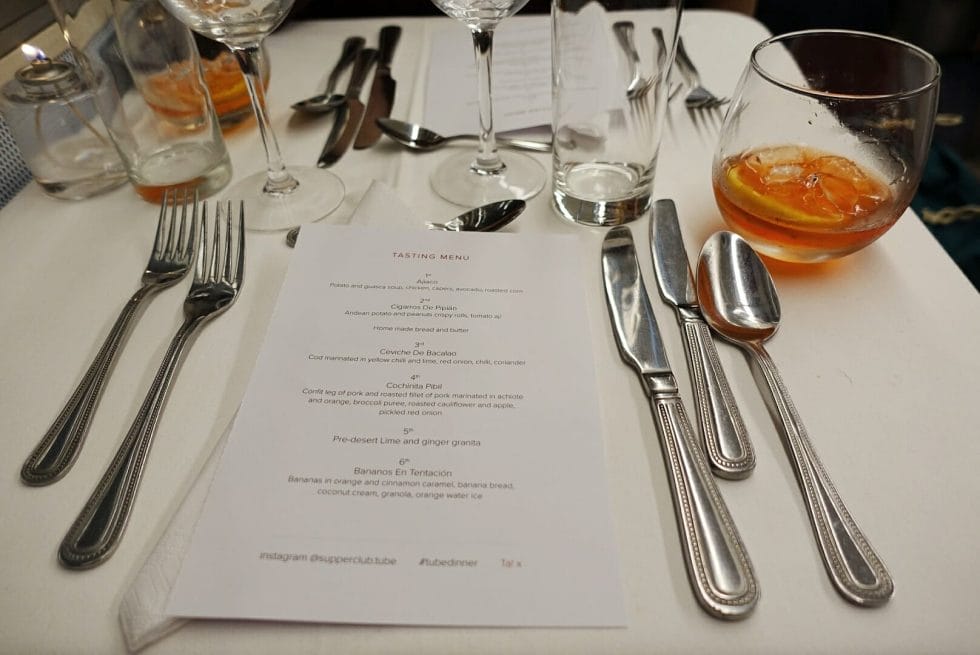 The menu for the evening on the table with cutlery and glasses