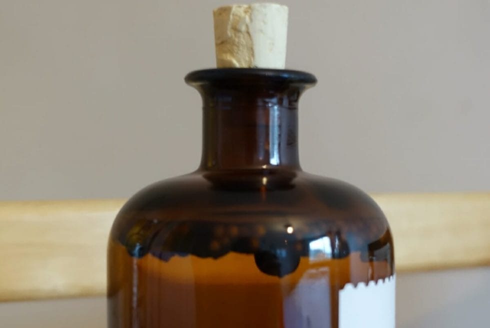 Close up of the bottle with floating botanicals