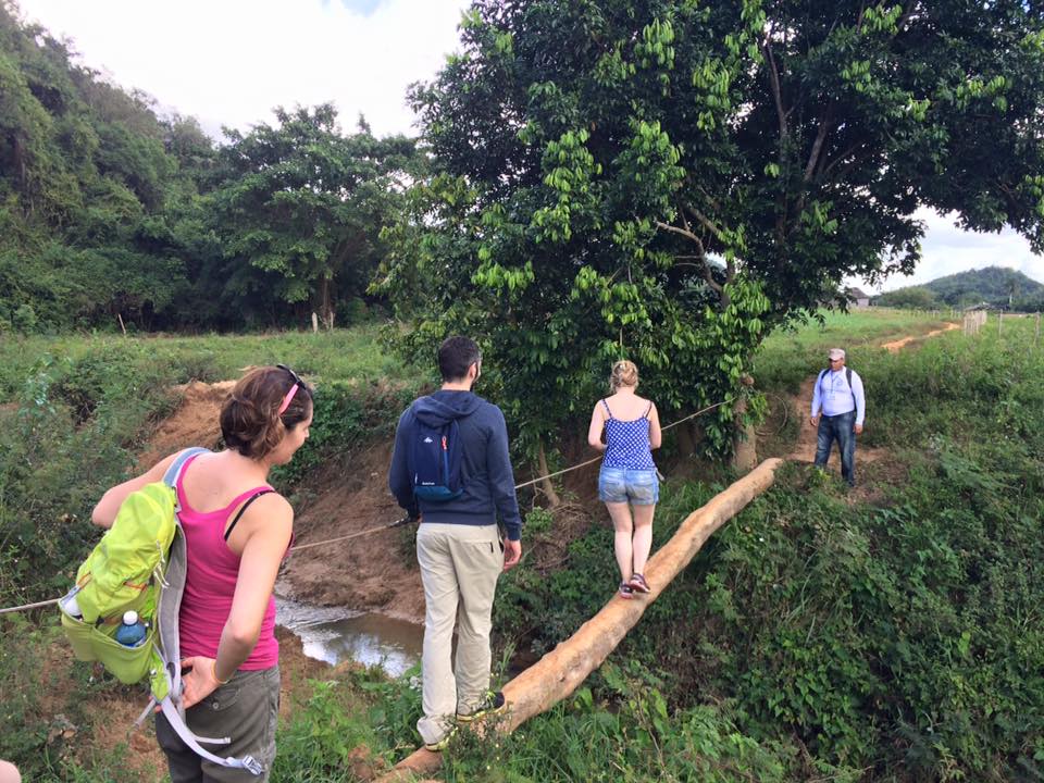 Katie's group crossing a log bridge in Cuba with Cuban Adventures