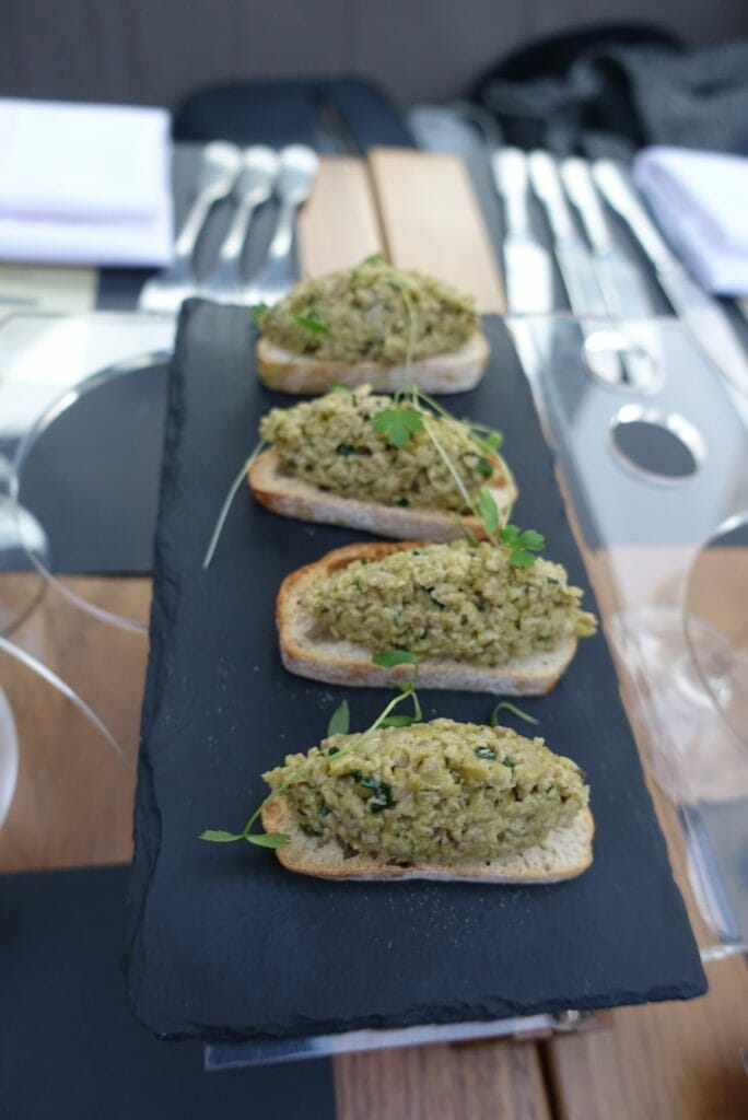 Green olive tapenade bruschetta served on a slate
