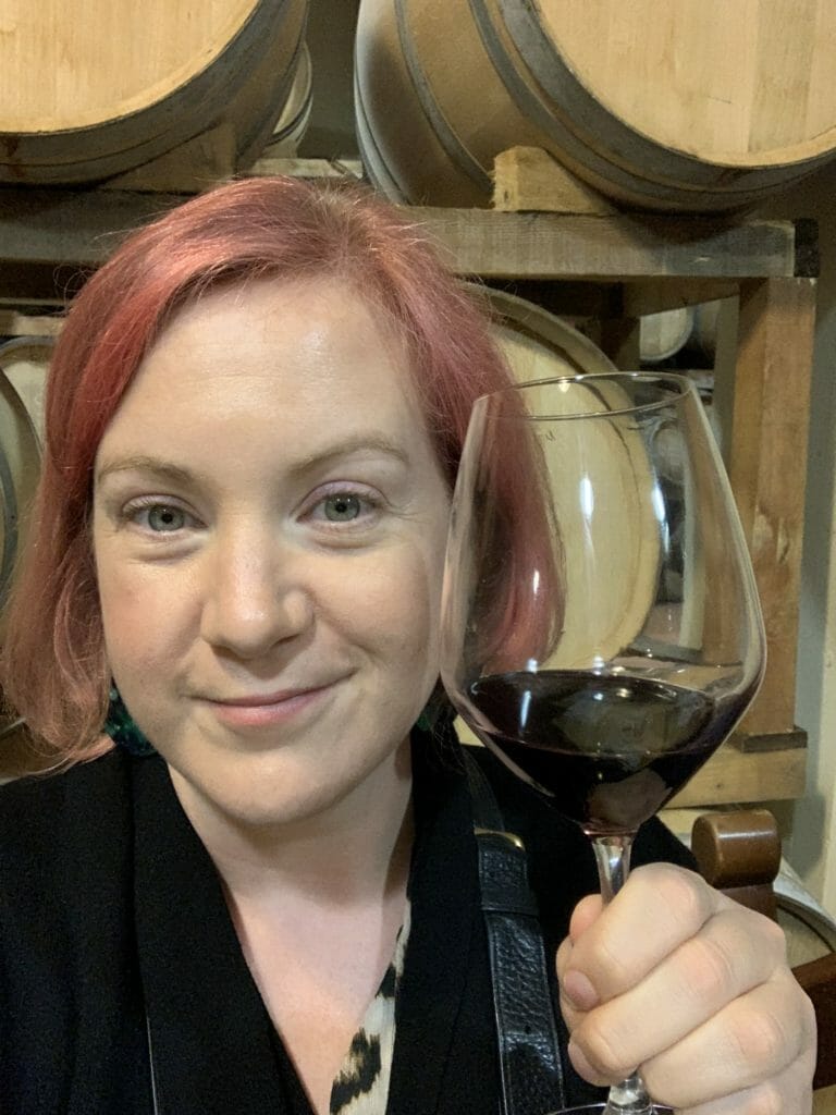 Katie holding a glass of Chianti red wine