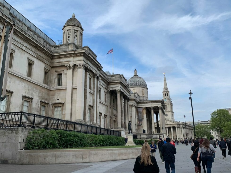 People walking past the front of the National Gallery towards the church