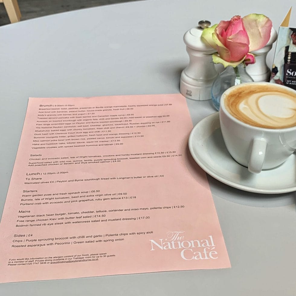 Pink brunch menu on grey table with latte cup and rose