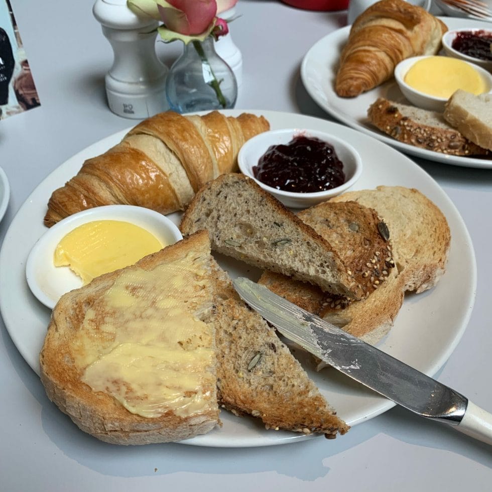 Plate of toast, crossiant with butter and jam