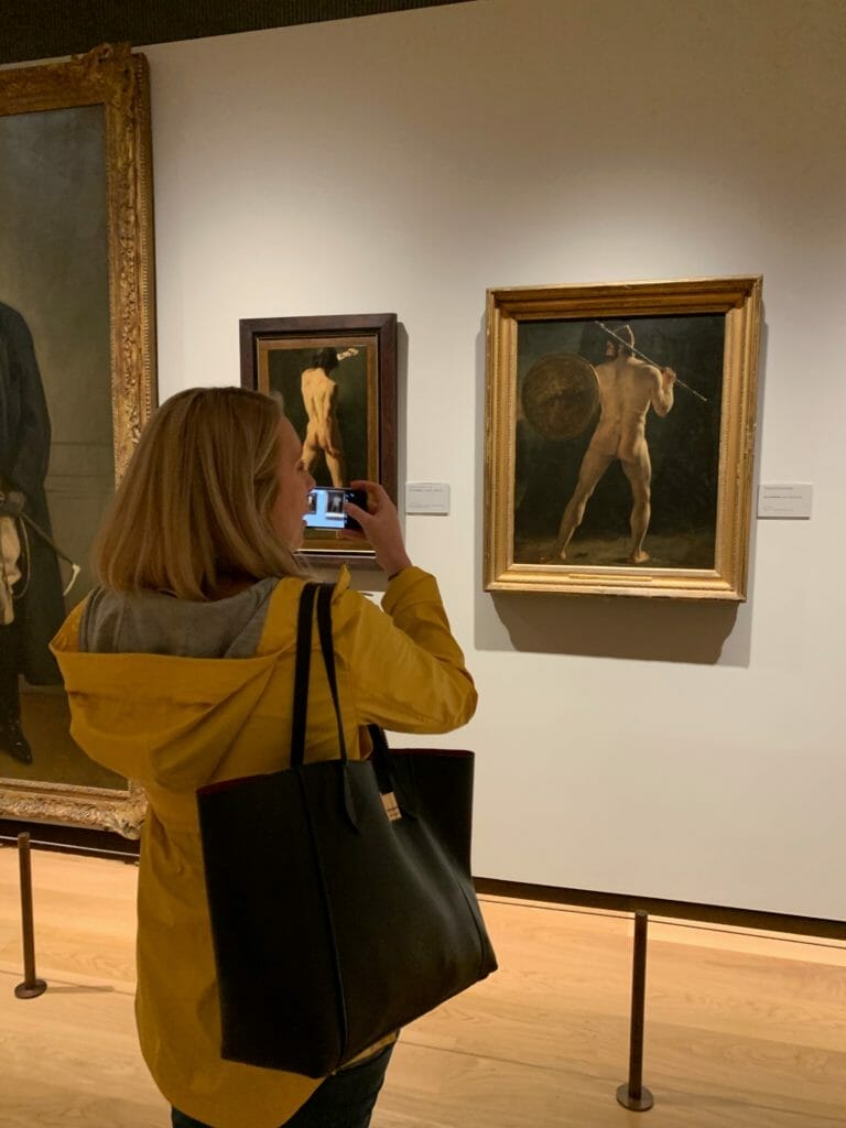 Laura taking a picture of 2 paintings with naked male butts!