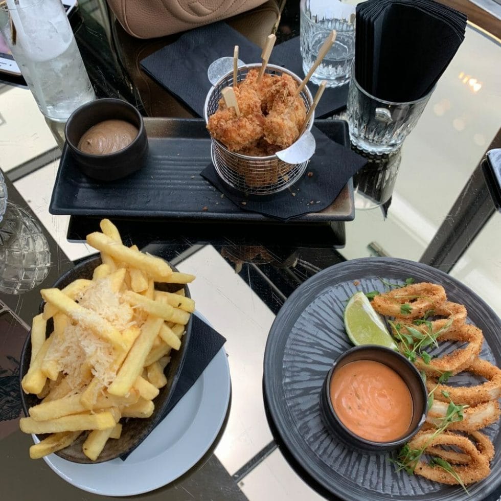 Fried chicken on sticks, sliced squid rings and chips with parmesan on top