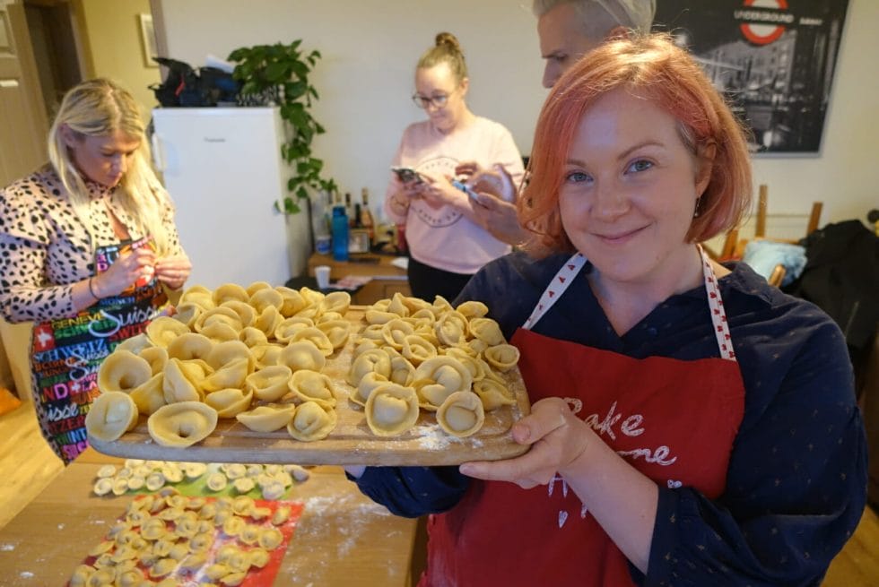 Katie holding up a board full of Russian dumplings made with Alla