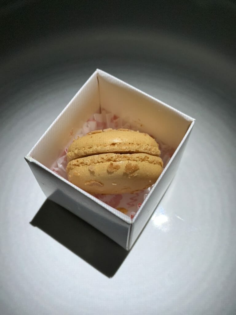Yellow macaron in a white ring box