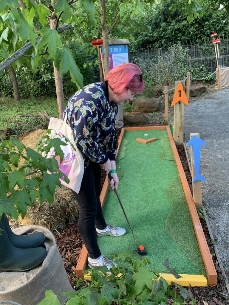 Katie putting her orange ball on hole 1 of the Plonk crazy golf