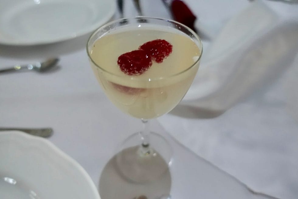 Cocktail with raspberries floating in it