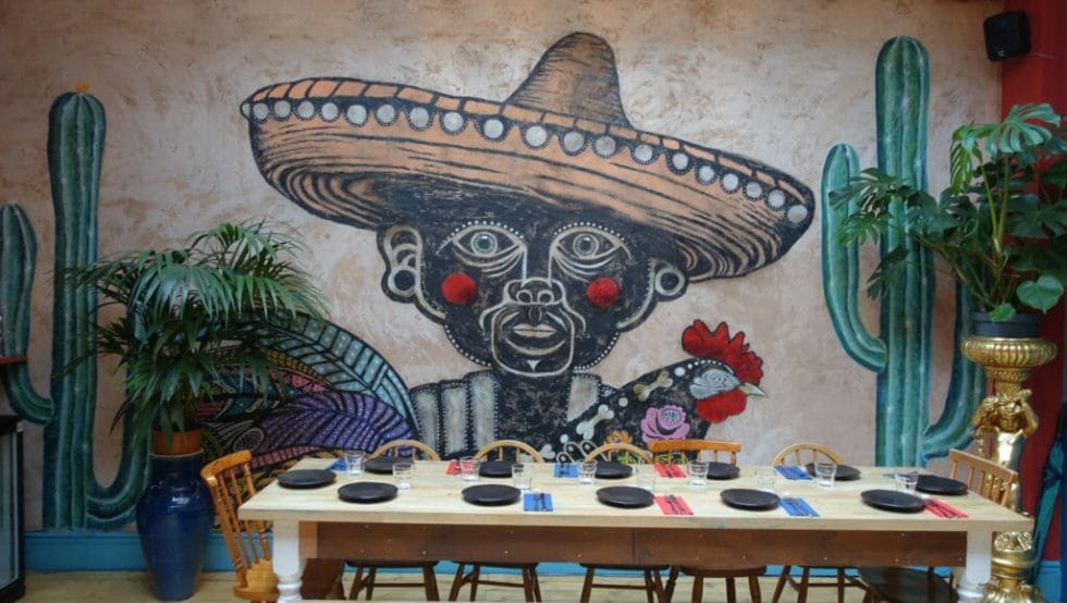 Mural of a man in a wide brimmed sombrero and cactus 
