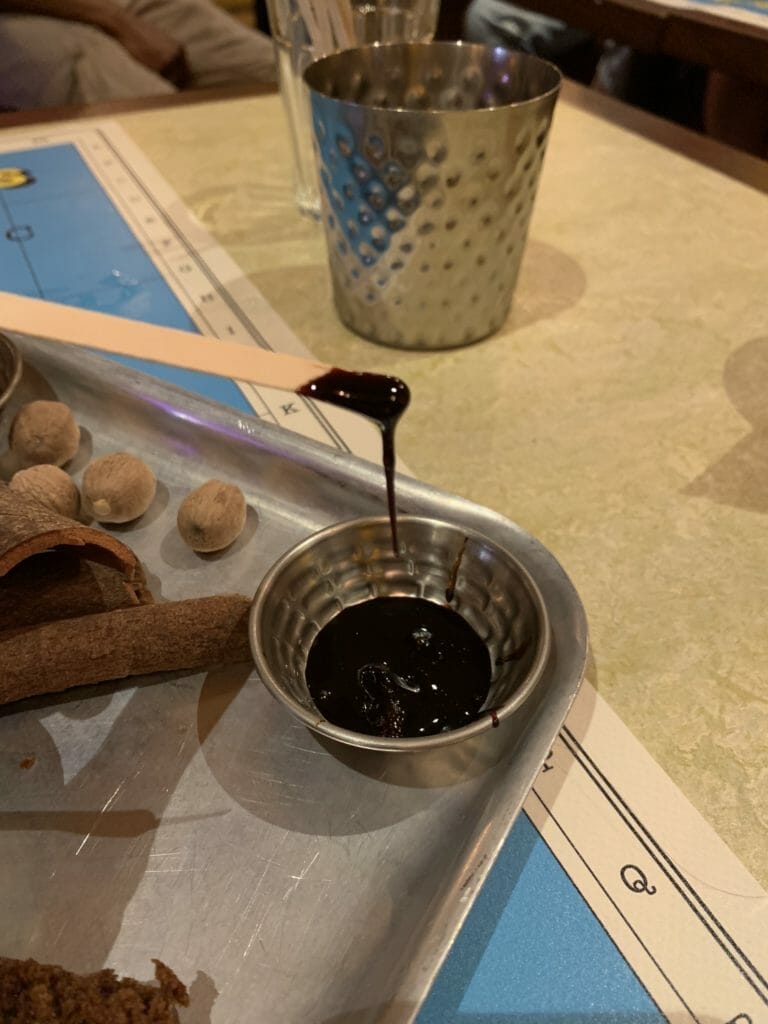 Dark brown molasses dripping off a spatula