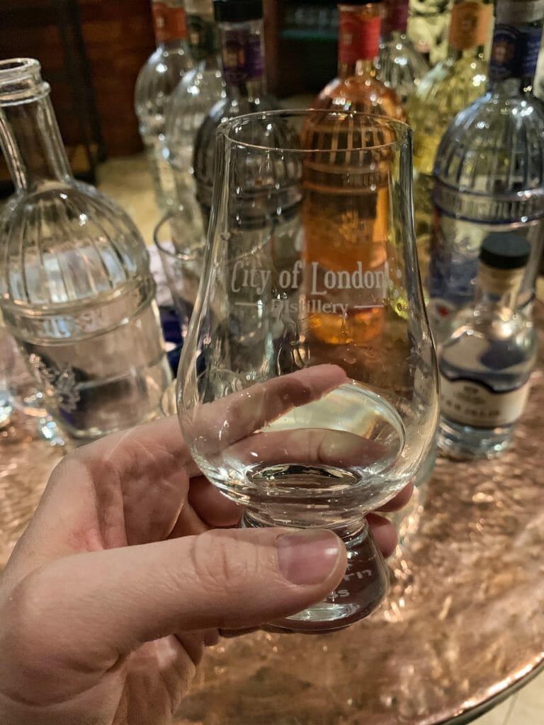Holding up the tasting glass of City of London dry gin