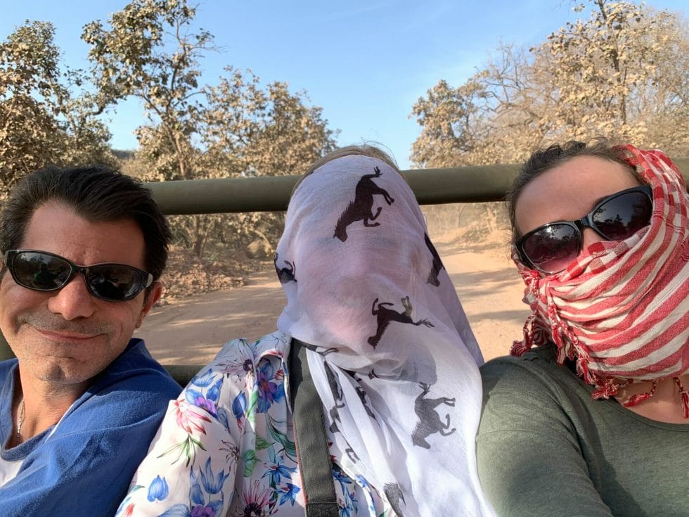 Using scarfs to cover mouth and face from the dust on safari in India