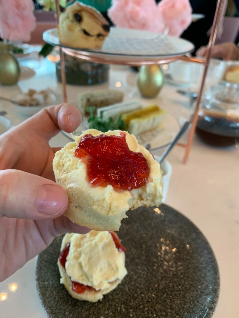 Partially eaten scone with jam and cream