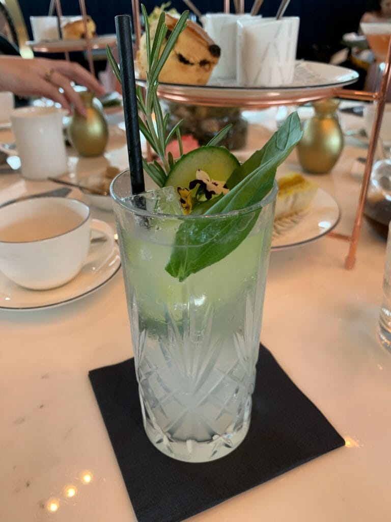 Weeping guitar cocktail garnished with herbs and cucumber