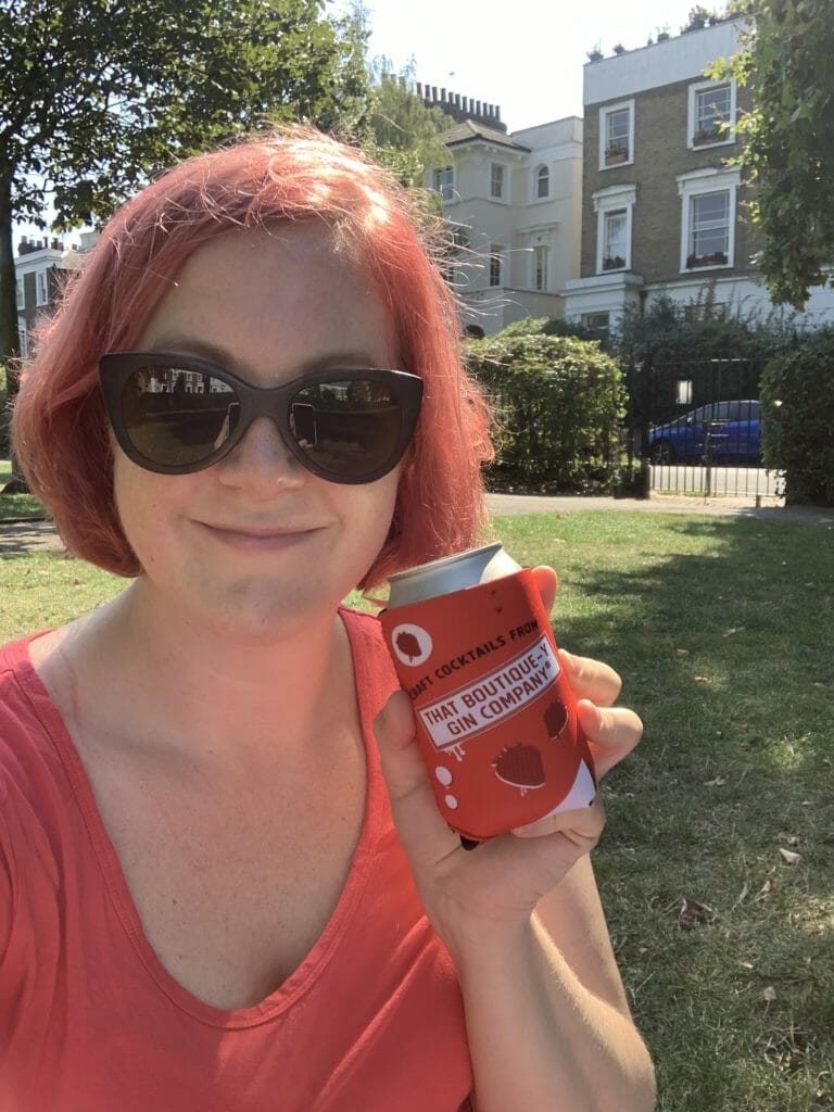 Katie looking very red with red hair, red top and red Boutiquey can