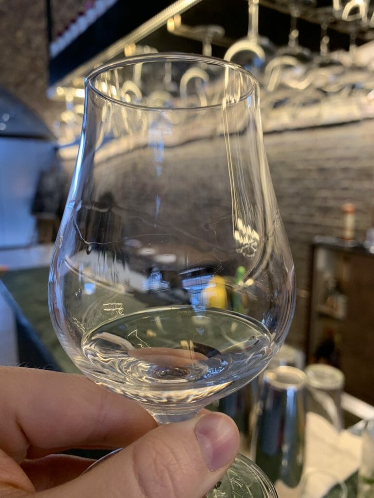 Tasting glass held up with gin it in