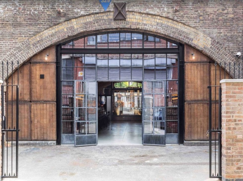 Entrance gates to 58 gin distillery with windows set in the railway arch